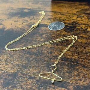 14k gold plated necklace with a unique hanger pendant and diamond detail.